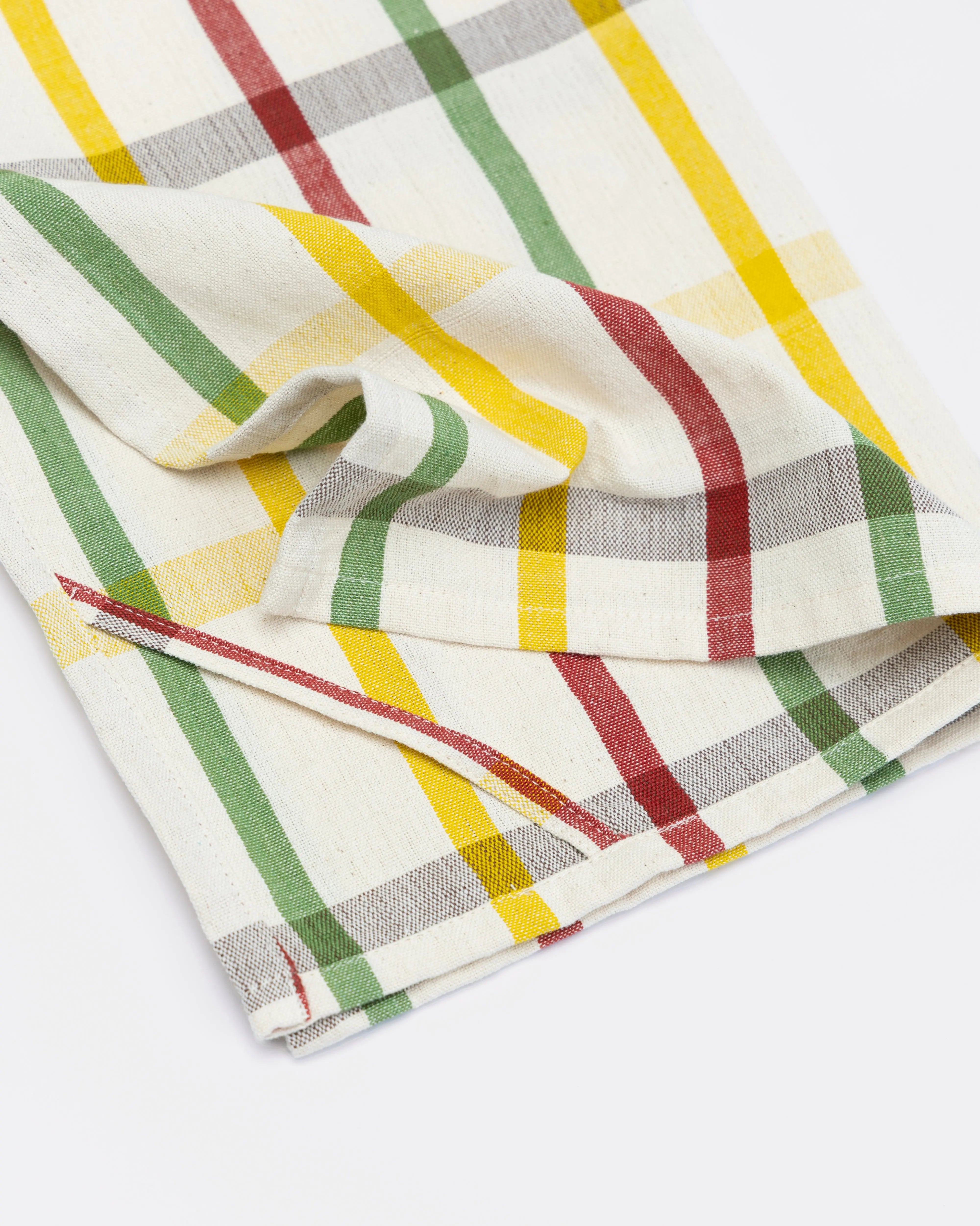 Plaid fabric with red, yellow, and green lines on a white background
